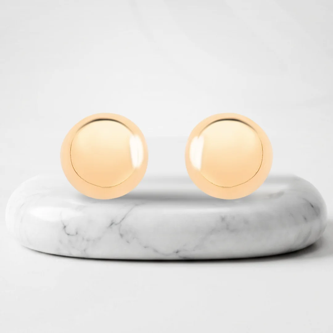 Aretes redondos con baño de oro Genova sobre un pedestal de mármol
