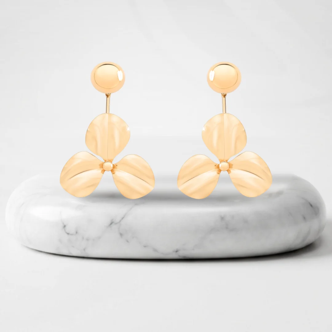 Aretes de flor con baño de oro Genova sobre un pedestal de mármol