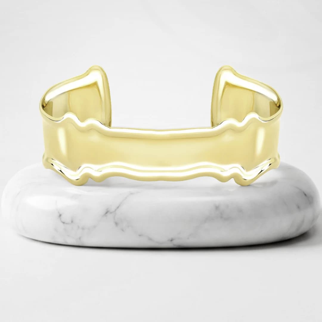 Cuff bracelet with Mont Blanc gold plating on a marble pedestal