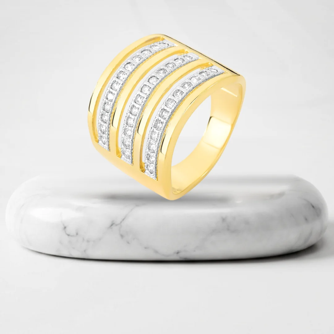 Wide ring with rows of zirconia with Quebec gold plating on a marble pedestal