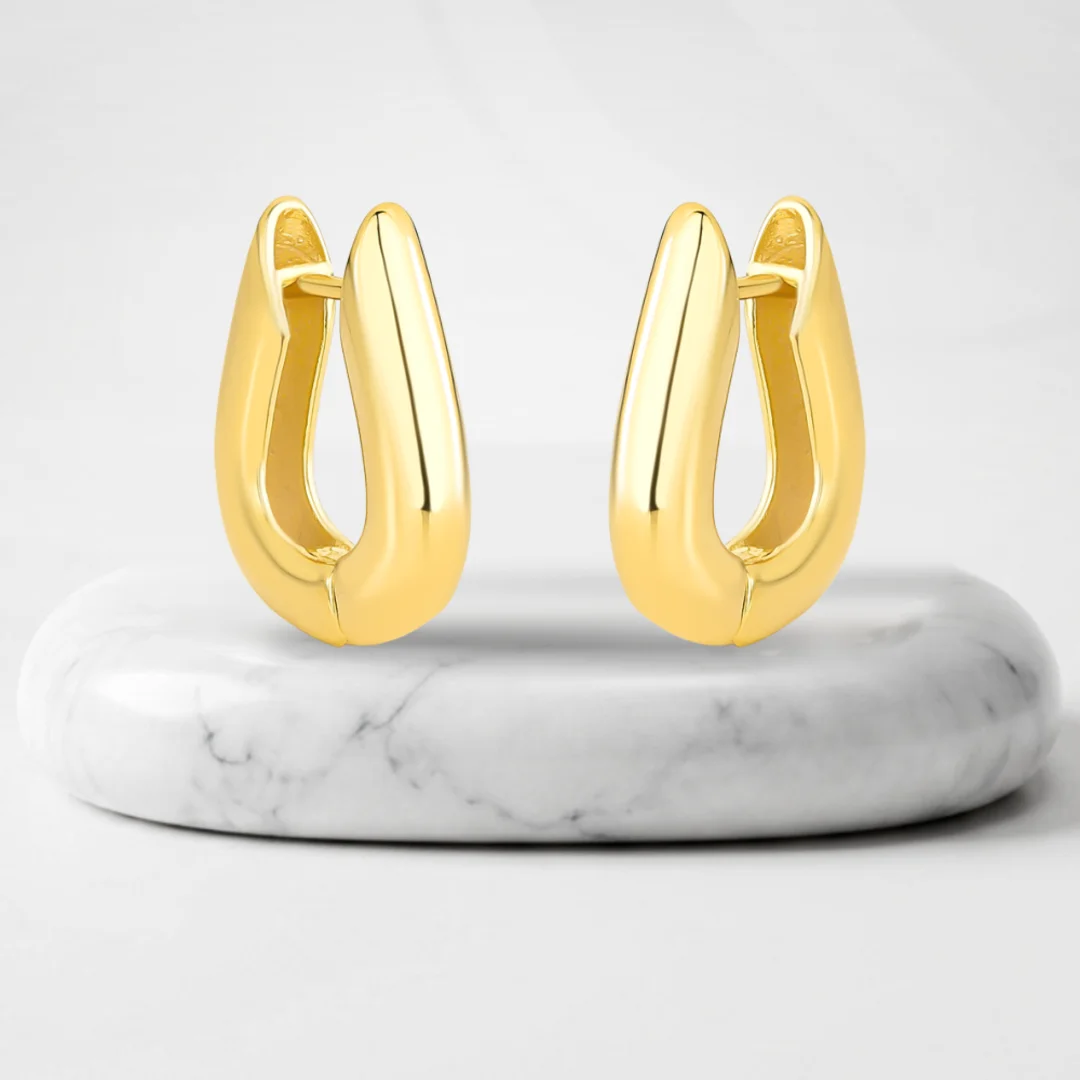 Pair of hoop earrings with Quebec gold plating on a marble pedestal