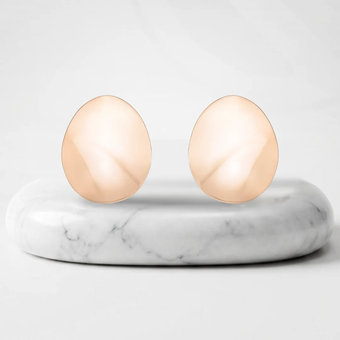 Aretes ovalados con baño de oro Riviera sobre un pedestal de mármol