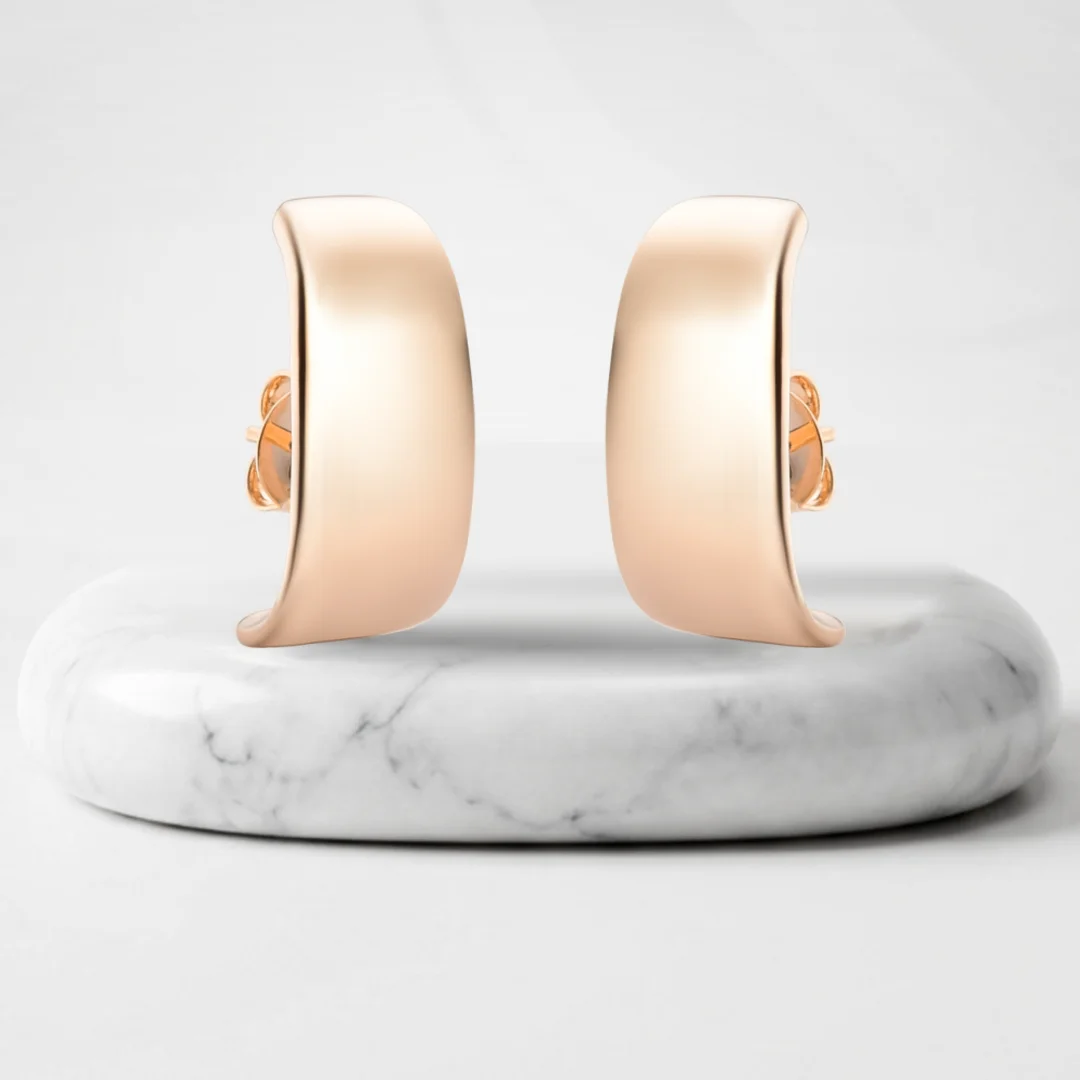 Par de aretes con baño de oro Riviera sobre un pedestal de mármol