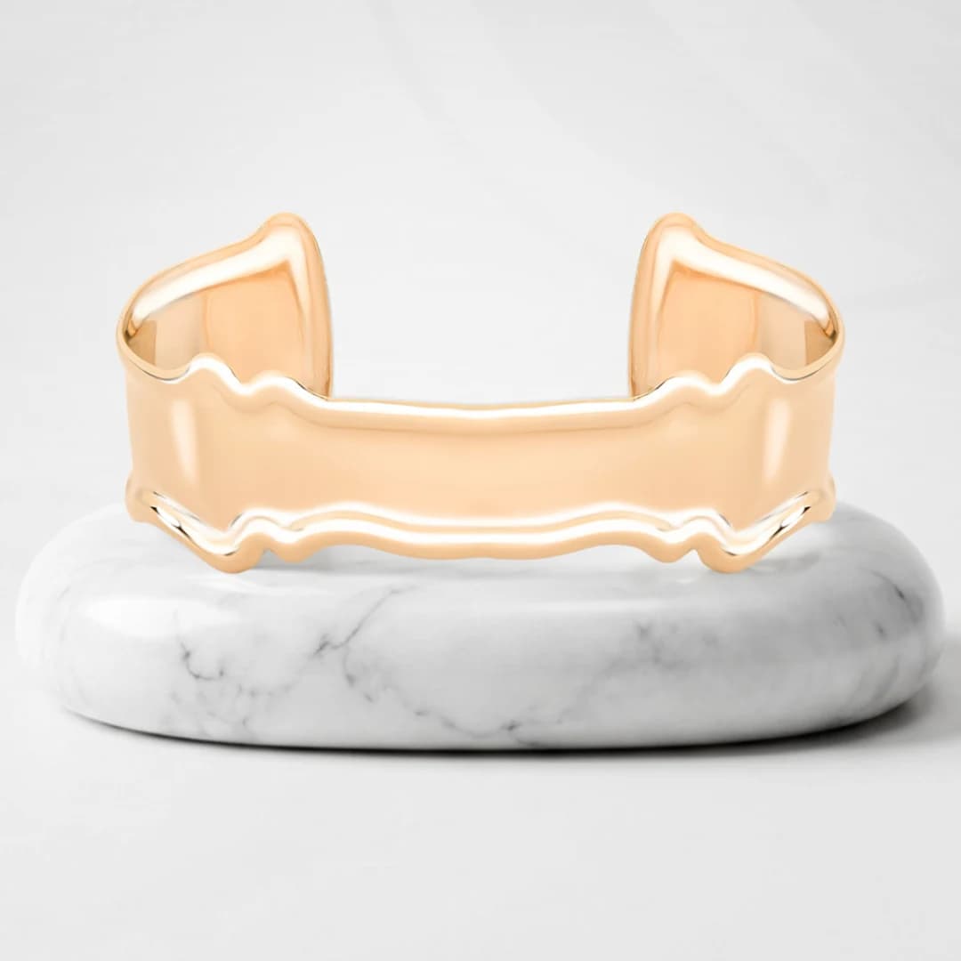 Cuff bracelet with Vienna gold plating on a marble pedestal