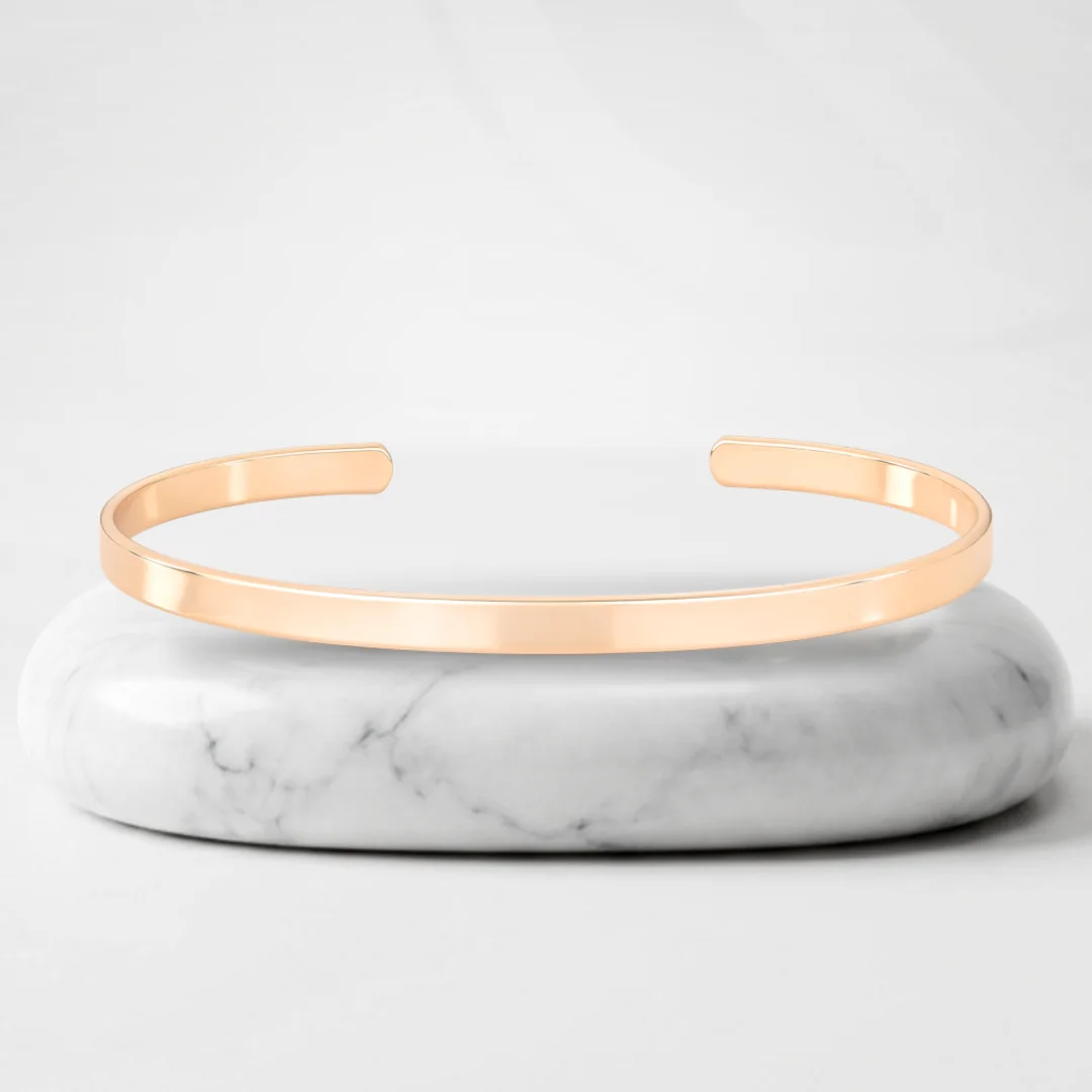 Thin bangle with Vienna gold plating on a marble pedestal